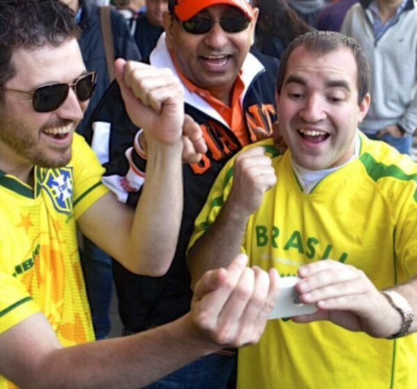 torcedores acompanhando resultados do futebol pelo celular